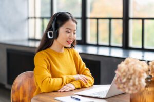 asian woman in headset speaking by conference call YGW3DR6 scaled 1