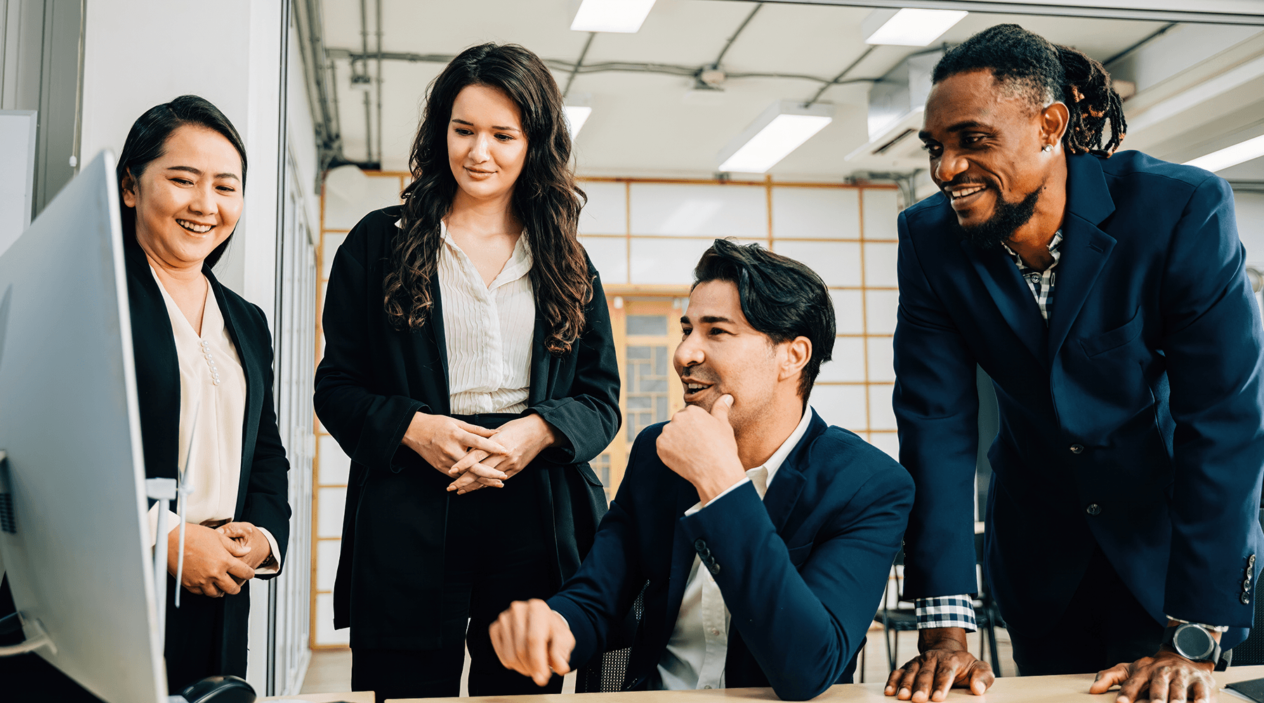 group of business people standing around a computer reading the best Microsoft Teams tips